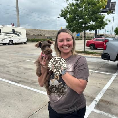 Happy family picking up their new Schnauzer puppy